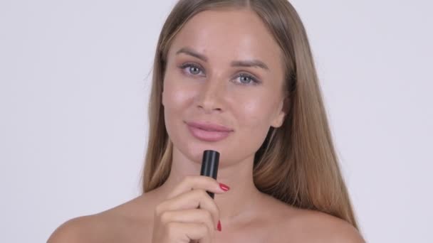 Cara de joven feliz hermosa mujer sin camisa que muestra el color del lápiz labial como concepto de belleza — Vídeo de stock