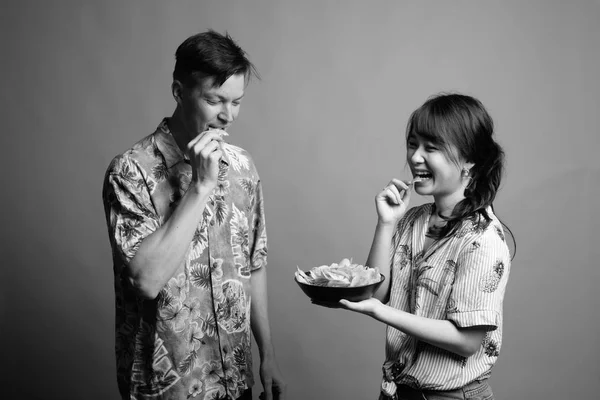 Casal de turistas multi étnicos com batatas fritas como lanche — Fotografia de Stock