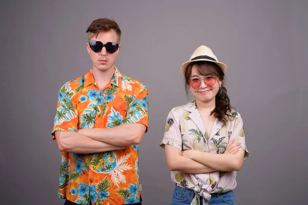 Couple touristique multi ethnique portant des lunettes de soleil et chemise hawaïenne — Photo