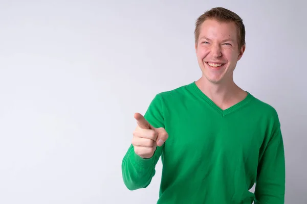 Портрет счастливого молодого красивого мужчины, смеющегося и указывающего пальцем — стоковое фото