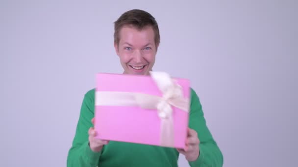 Gelukkig opgewonden jongeman dansen met de doos van de gift klaar voor Valentijnsdag — Stockvideo