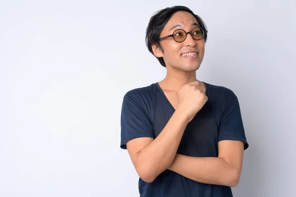 Retrato de feliz hombre japonés sonriendo y pensando —  Fotos de Stock