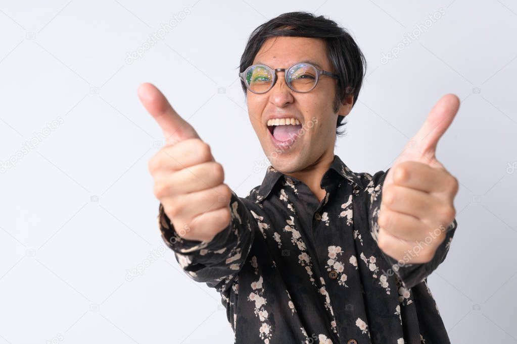 Portrait of happy Japanese businessman giving thumbs up