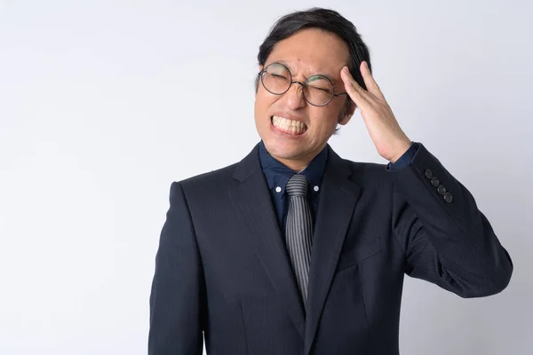 Retrato de homem de negócios japonês estressado em terno com dor de cabeça — Fotografia de Stock