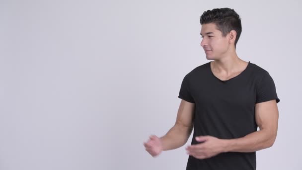 Счастливый молодой привлекательный многонациональный мужчина показывает что-то — стоковое видео