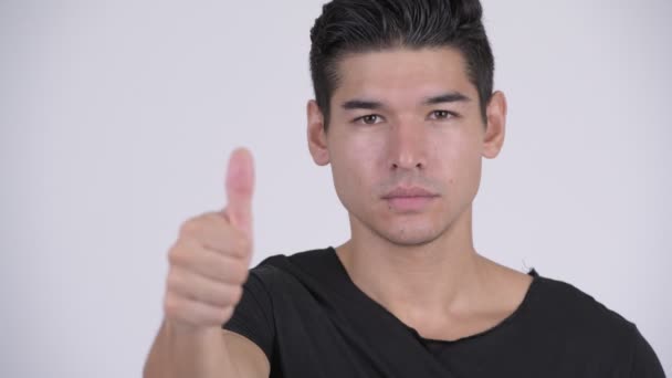 Лицо счастливого молодого красивого многоэтничного мужчины, подающего большие пальцы — стоковое видео