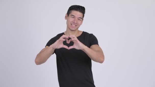 Mladý muž šťastný multietnické gestem ruky srdce — Stock video