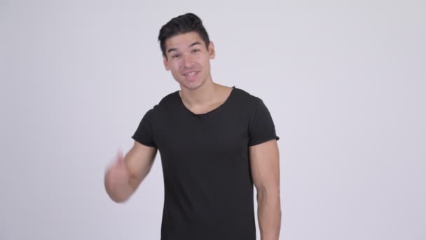 Happy young handsome multi-ethnic man with call me gesture — Stock Video