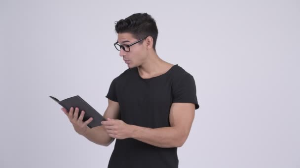 Νεαρό όμορφος πολυεθνικό nerd άνθρωπος διαβάζοντας το βιβλίο — Αρχείο Βίντεο