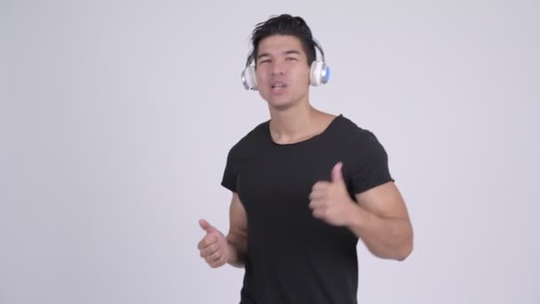 Gelukkig multi-etnische jongeman dansen terwijl u luistert naar muziek — Stockvideo