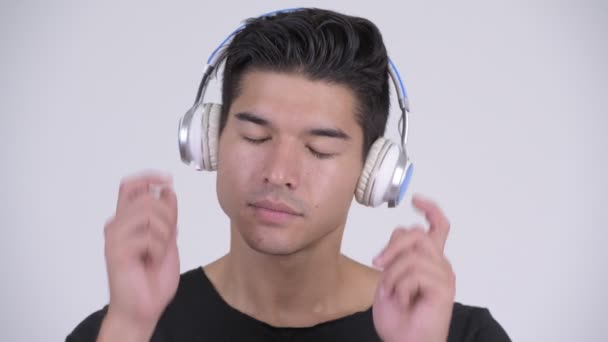 Fiatal jóképű férfi többnemzetiségű hallgató-hoz zene arca — Stock videók