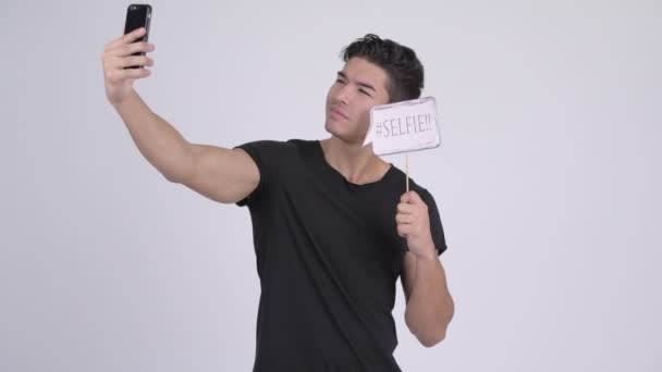Boldog fiatal jóképű férfi többnemzetiségű véve papír jel selfie — Stock videók