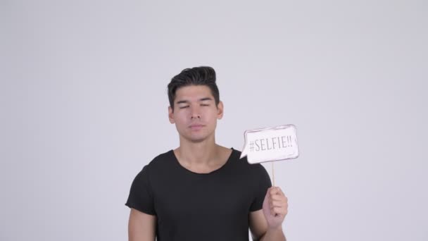 Glücklicher junger gutaussehender multiethnischer Mann mit Selfie-Papierschild — Stockvideo