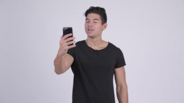 Mutlu genç yakışıklı çok etnik gruptan oluşan adam görüntülü görüşme ve telefon gösterilen