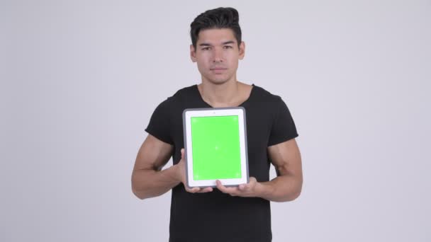 Felice giovane uomo multietnico bello mostrando tablet digitale — Video Stock