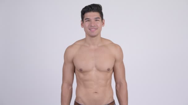 Счастливый молодой красивый мускулистый мужчина без рубашки улыбается — стоковое видео