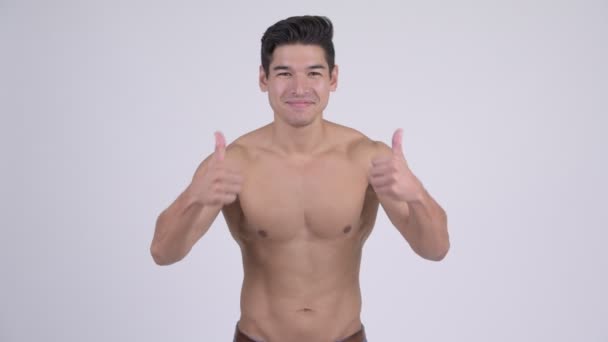 Feliz joven guapo musculoso sin camisa hombre dando pulgares hacia arriba y mirando emocionado — Vídeos de Stock