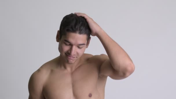 Jovem bonito muscular sem camisa homem escovando cabelo de volta — Vídeo de Stock