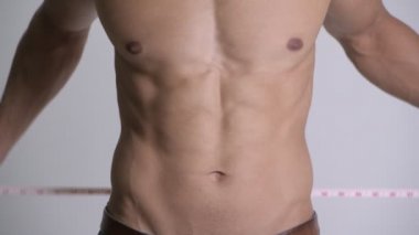 Genç gömleksiz kaslı adam bel ölçüm closeup