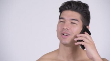 Mutlu genç gömleksiz kaslı adamın telefonda konuşurken yüzünü