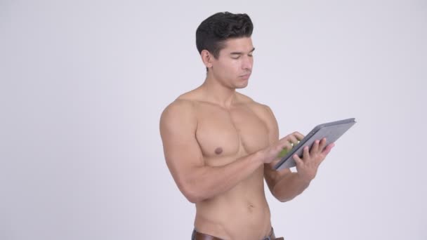 Счастливый молодой без рубашки мускулистый человек думает, используя цифровой планшет — стоковое видео