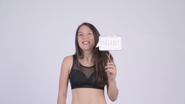 Jeune femme heureuse multi-ethnique avec selfie papier signe prêt pour la salle de gym — Video