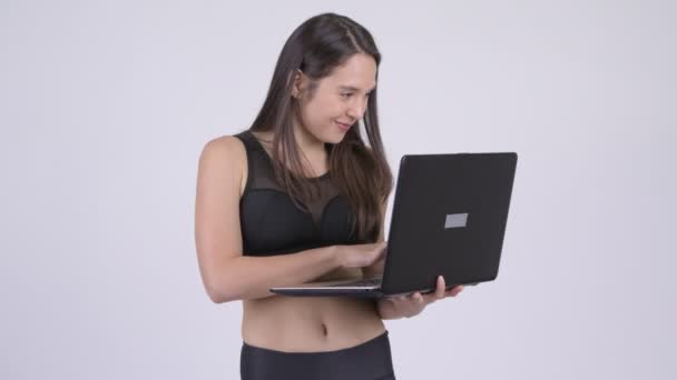 Joven feliz multi-étnica mujer usando portátil listo para el gimnasio — Vídeos de Stock