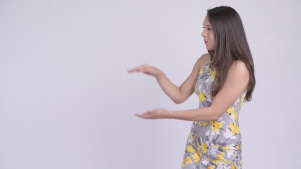Fiatal, boldog többnemzetiségű turista nő harapós ujjait, és bemutatja, hogy valami — Stock videók