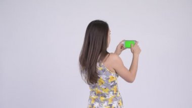 Arkadan görünüş genç çok etnik gruptan oluşan turist kadın alarak resmi telefon ile
