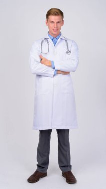 Tüm vücut çekim silah ile gülümseyen genç mutlu adam doktor geçti