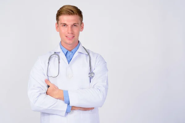 Happy young handsome blonde man doctor with arms crossed — Stock Photo, Image