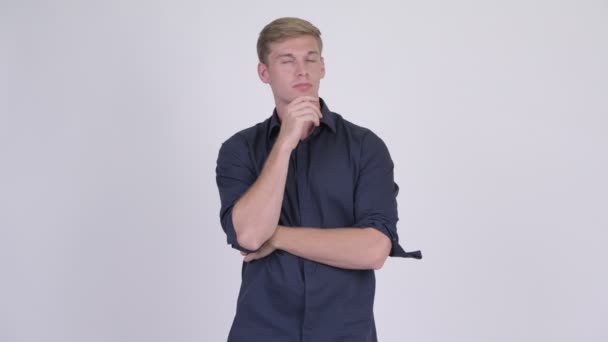 Junge hübsche blonde Geschäftsmann denken und suchen nach oben — Stockvideo