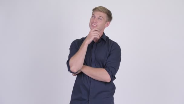 Junge glückliche blonde Geschäftsmann lächelt und denkt — Stockvideo