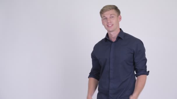 Счастливый молодой красивый блондин бизнесмен показывает что-то — стоковое видео