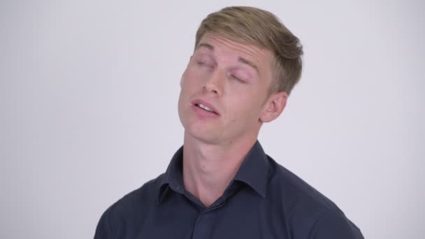 Молодой напряженный блондин бизнесмен выглядит уставшим и скучающим — стоковое видео