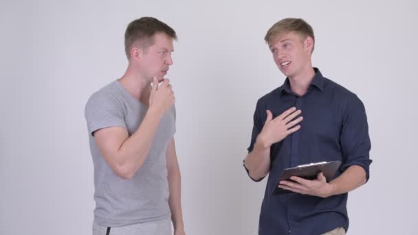 Två stressade unga män läsning på Urklipp och få dåliga nyheter ihop — Stockvideo