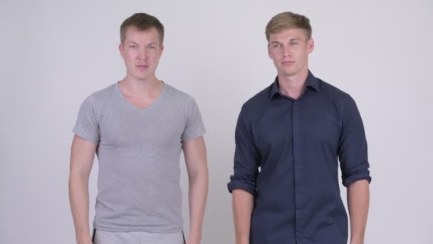 Två glada unga stiliga män ger tummen upp tillsammans — Stockvideo