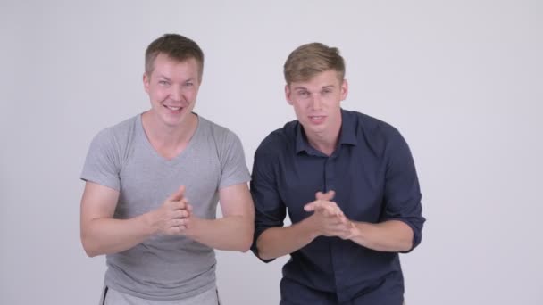 Zwei glückliche junge Männer, die gute Nachrichten zusammen bekommen — Stockvideo
