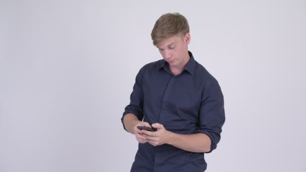 Feliz joven guapo rubia hombre de negocios utilizando el teléfono — Vídeos de Stock