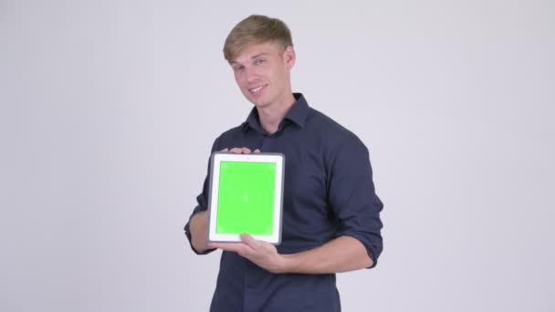 Szczęśliwy młody przystojny biznesmen wyświetlone cyfrowy tablicowy — Wideo stockowe