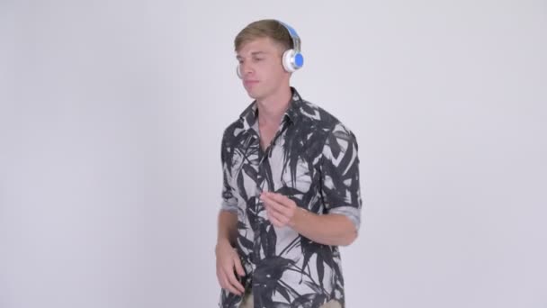 Glücklicher junger gutaussehender Touristenmann, der Musik hört und tanzt — Stockvideo