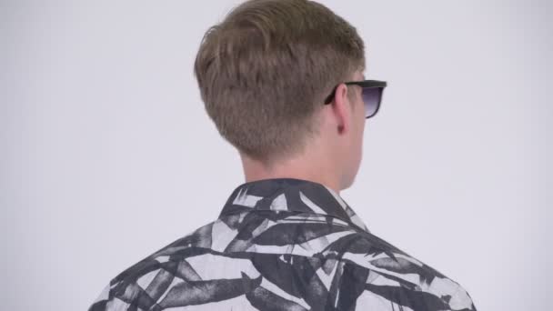 Лицо молодого привлекательного туриста, оглядывающегося назад и снимающего солнечные очки — стоковое видео