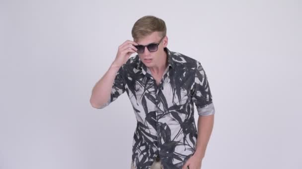 Junger gutaussehender Touristenmann nimmt Sonnenbrille ab und sieht schockiert aus — Stockvideo
