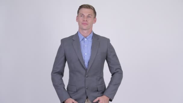 Jonge knappe zakenman in pak met gekruiste armen — Stockvideo
