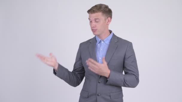 Gelukkig jonge knappe zakenman presenteren iets — Stockvideo