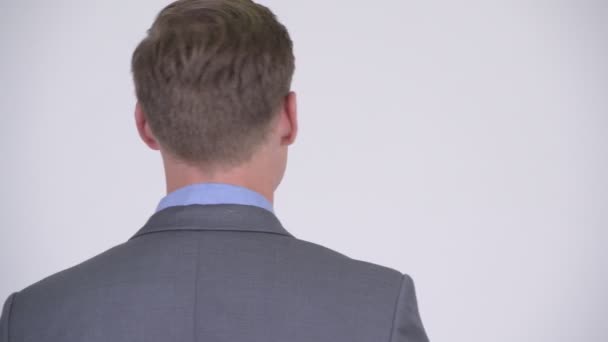 Vista trasera de joven hombre de negocios guapo mirando hacia atrás — Vídeos de Stock