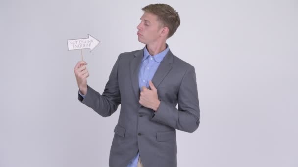 Молодой привлекательный бизнесмен держит в руках недостаточно пьяный бумажный знак — стоковое видео