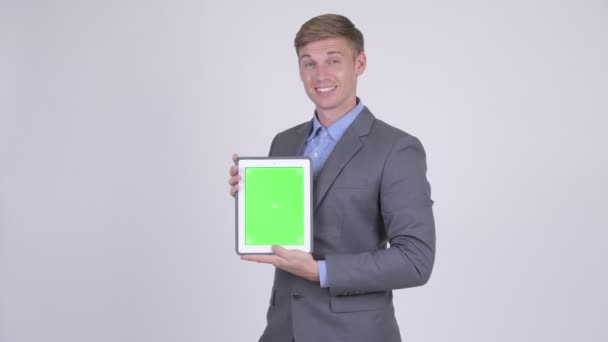 Jovem empresário bonito feliz mostrando tablet digital — Vídeo de Stock