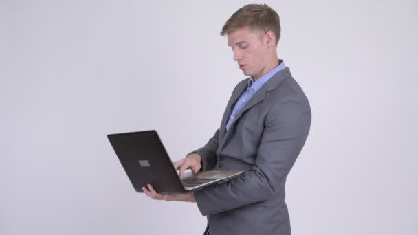 Молодий красивий бізнесмен розмовляє під час використання ноутбука — стокове відео