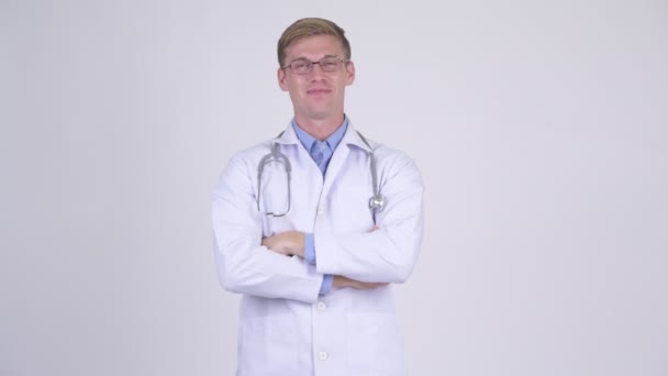 Joyeux jeune homme beau médecin portant des lunettes avec les bras croisés — Video